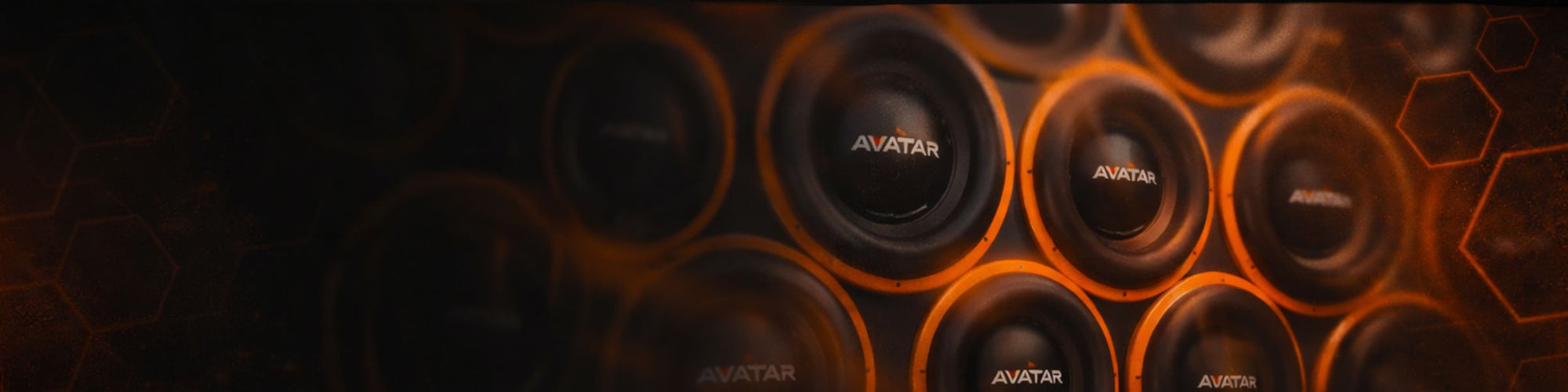 “Close-up of multiple Avatar car audio subwoofers arranged in a wall with orange accent lighting.”