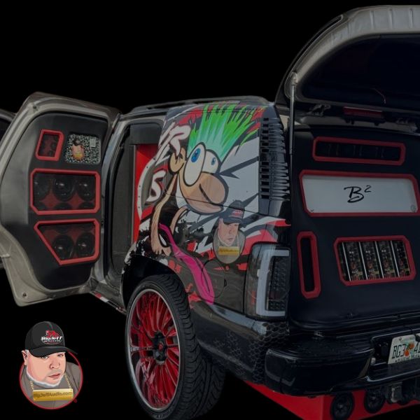 “Custom SUV with doors open displaying large red-trimmed speakers and subwoofers, featuring graffiti-style wrap and red wheels on a black background.”