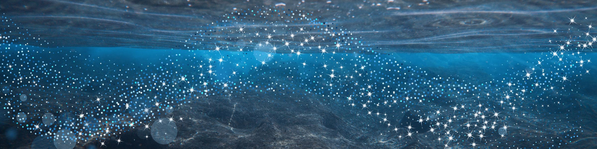 “Underwater ocean scene with sunlight filtering through the surface and sparkling light particles floating in blue water.”